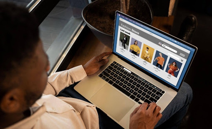  A man using a laptop to shop for clothes at an online clothing store.